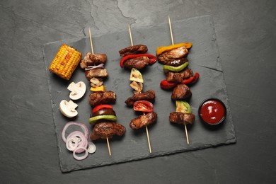 Delicious shish kebabs served on grey textured table, top view