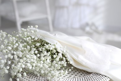 Wedding dress and flowers indoors, closeup view