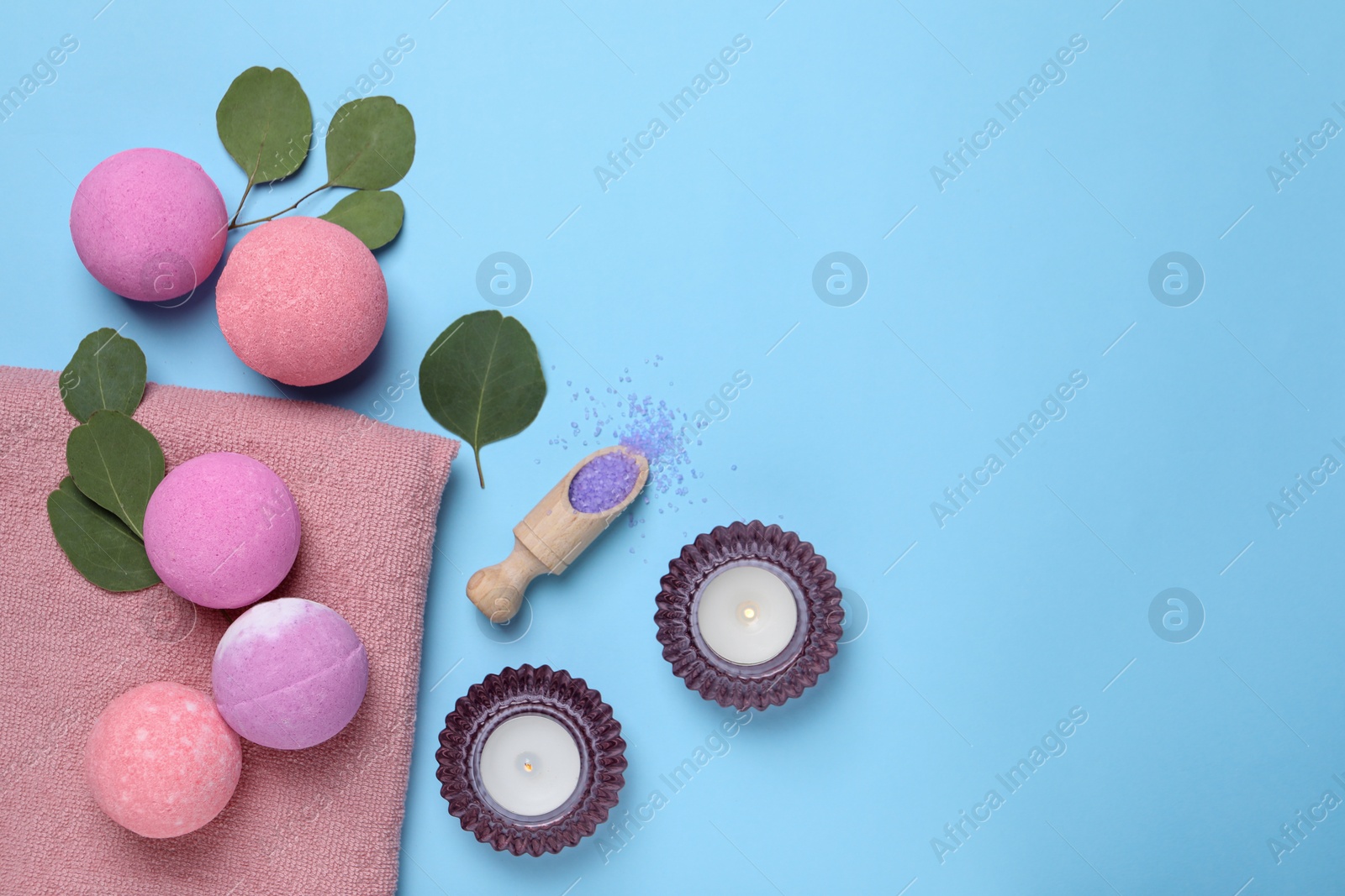 Photo of Bath bombs, eucalyptus leaves, burning candles and sea salt on light blue background, flat lay. Space for text