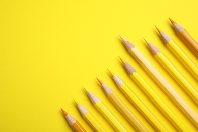 Photo of Flat lay composition with color pencils on yellow background, space for text
