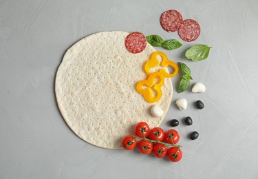 Photo of Flat lay composition with base and ingredients for pizza on light background