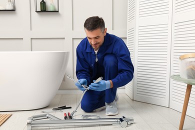 Photo of Professional plumber installing water tap in bathroom