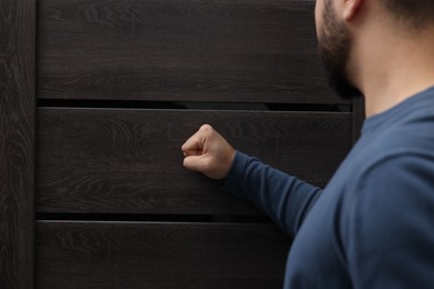 Collection agent knocking on wooden door, closeup