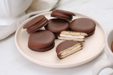 Photo of Plate with delicious choco pies on white table, closeup