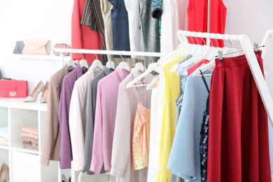 Photo of Racks with different stylish clothes in boutique