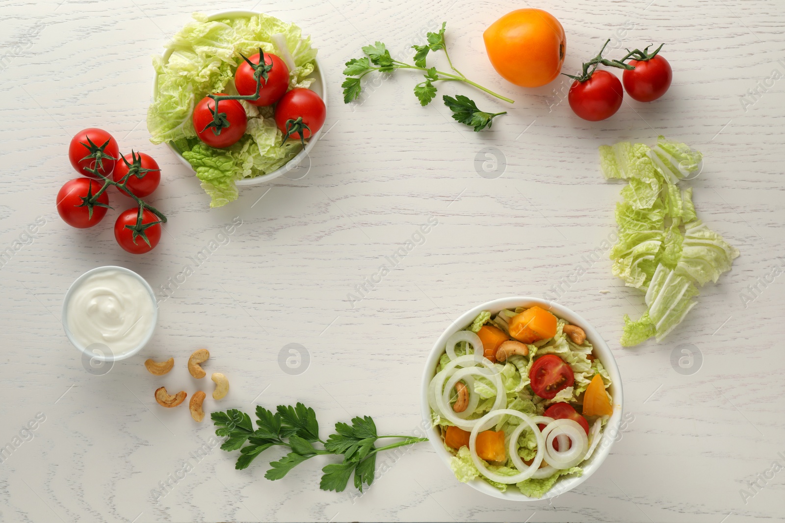 Photo of Bowl of delicious salad with Chinese cabbage and different ingredients on white wooden table, flat lay. Space for text