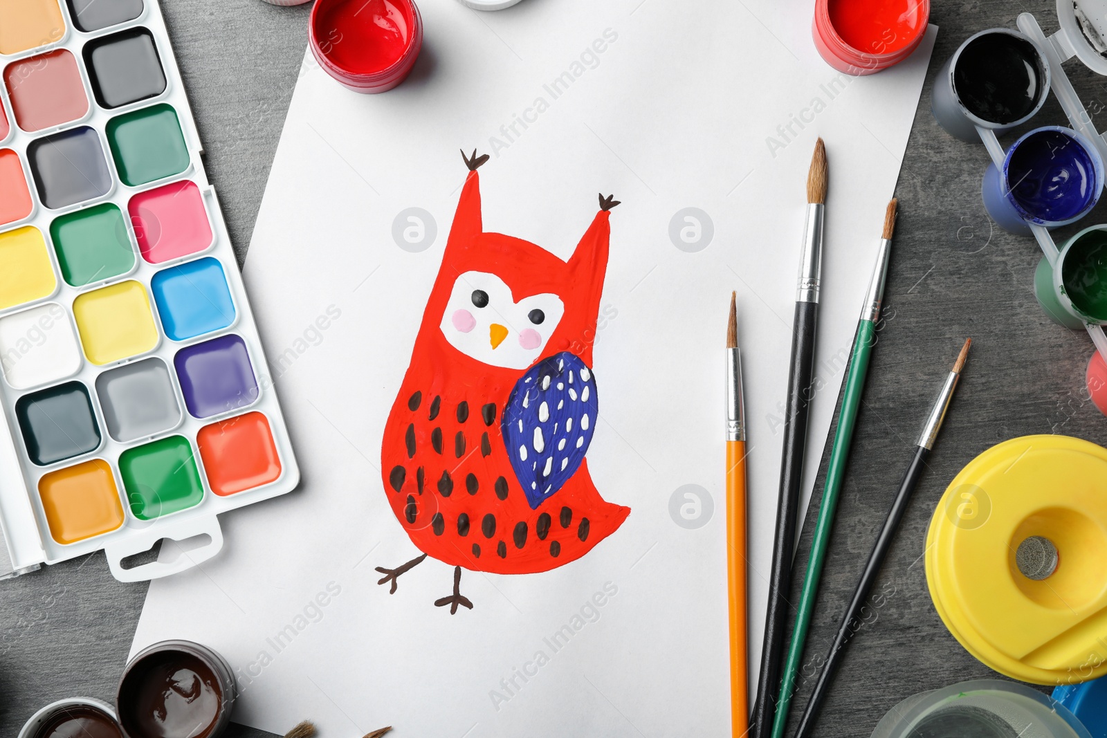 Photo of Flat lay composition with child's painting of owl on grey table