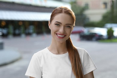 Portrait of happy young woman in casual clothes outdoors. Attractive lady smiling and looking into camera