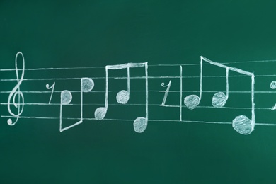 Music staff with treble clef and notes written on chalkboard