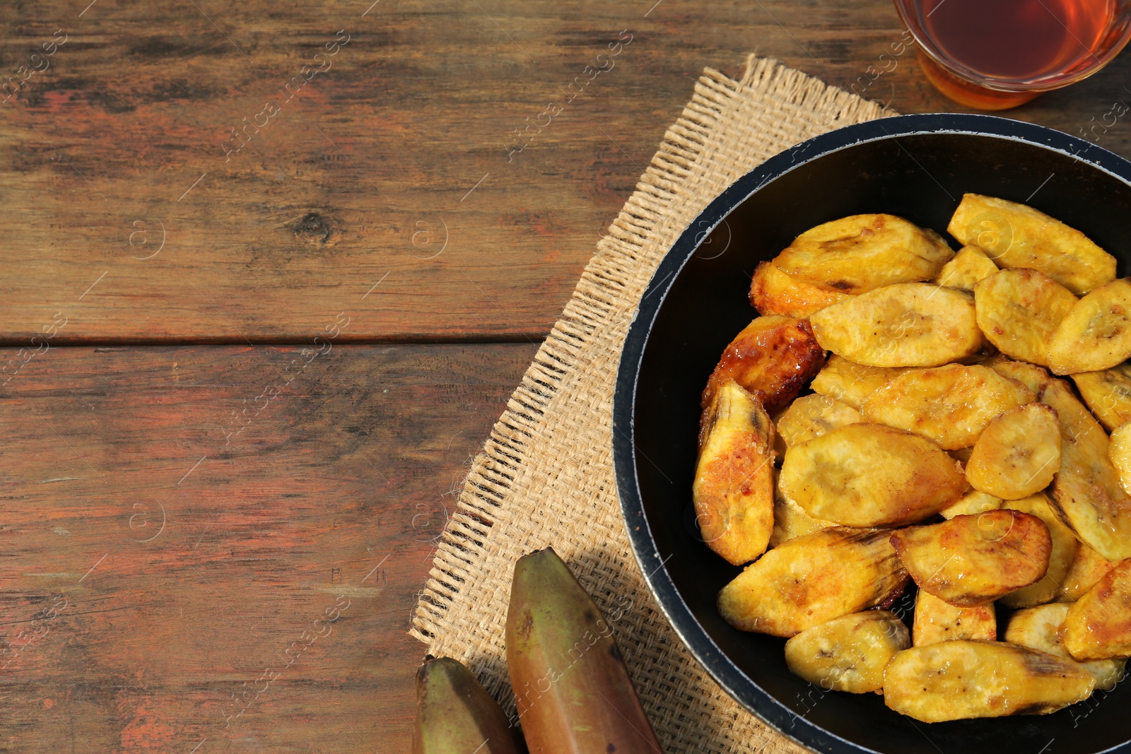 Photo of Flat lay composition with deep fried banana slices on wooden table. Space for text