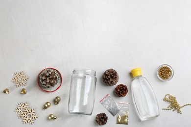 Materials for handmade snow globe on light table, flat lay. Space for text