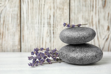 Photo of Spa stones with lavender flowers on table