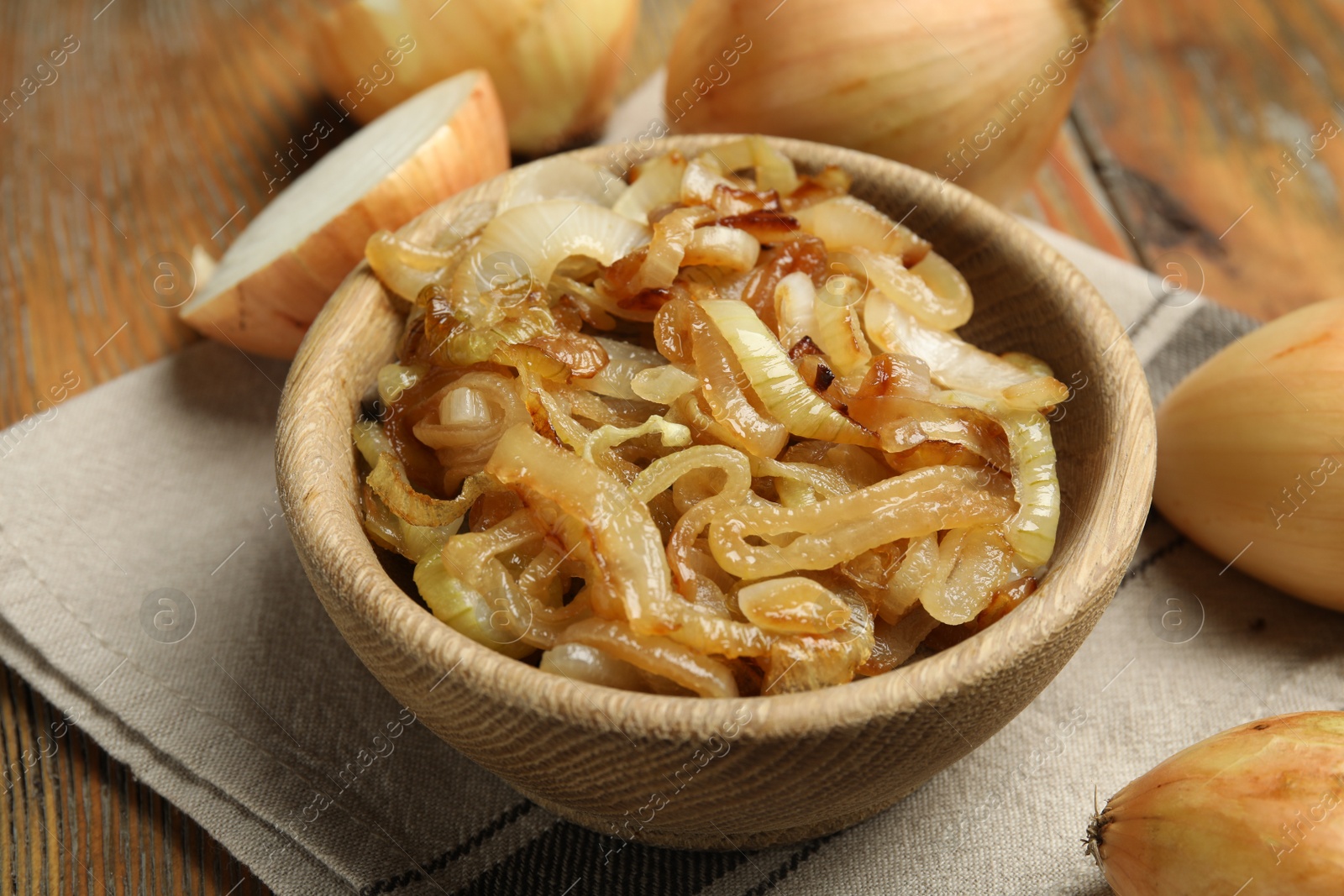 Photo of Tasty fried onion on wooden table, closeup