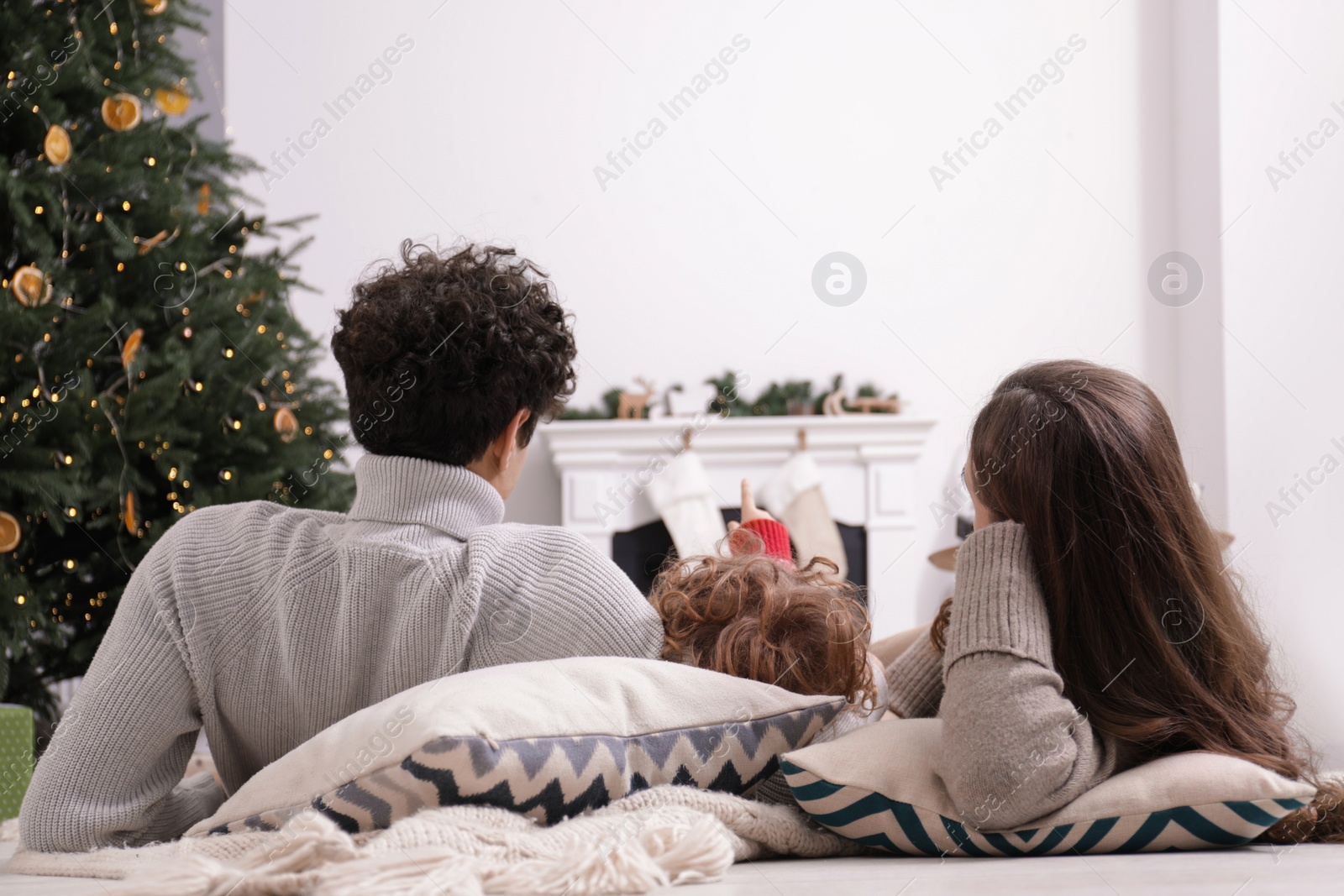 Photo of Family watching movie via video projector at home, back view