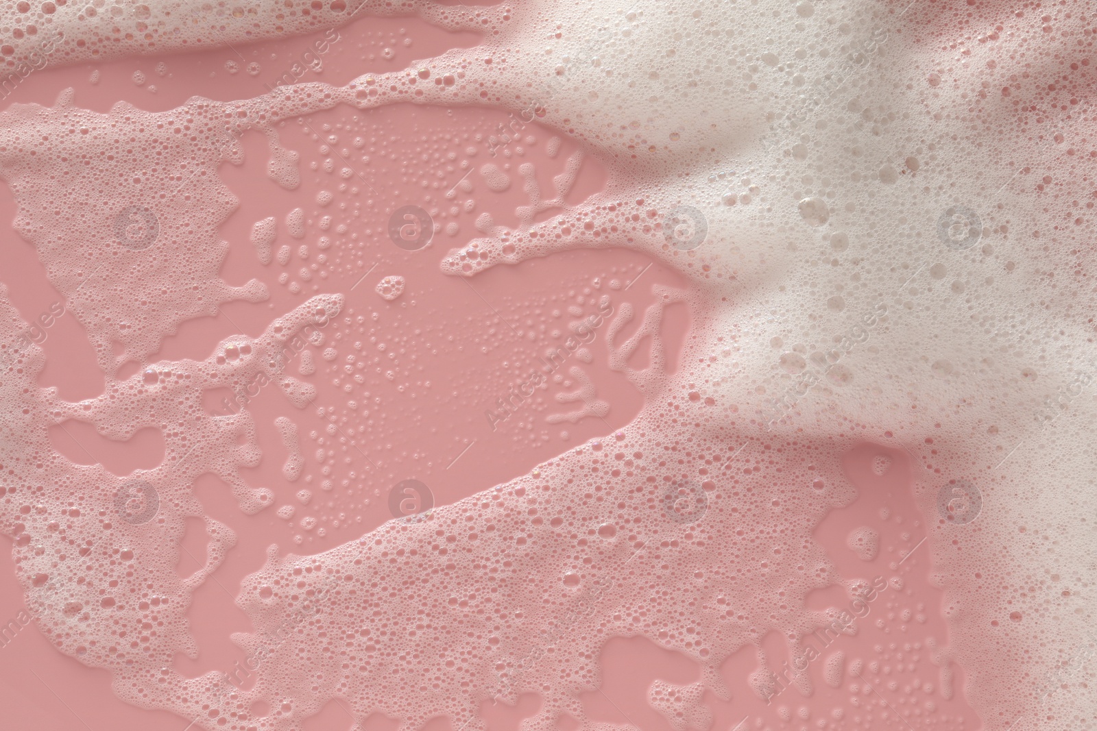 Photo of White washing foam on pale pink background, top view