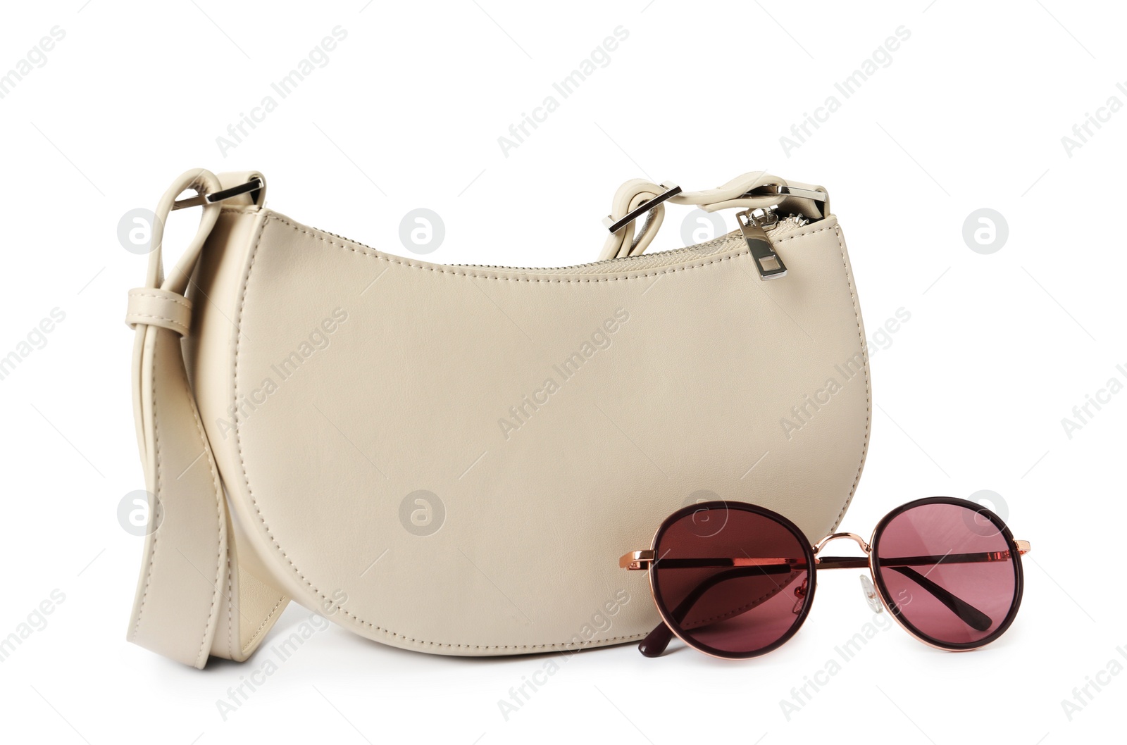 Photo of Stylish baguette bag with sunglasses on white background