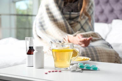 Different cold remedies and sick woman on background