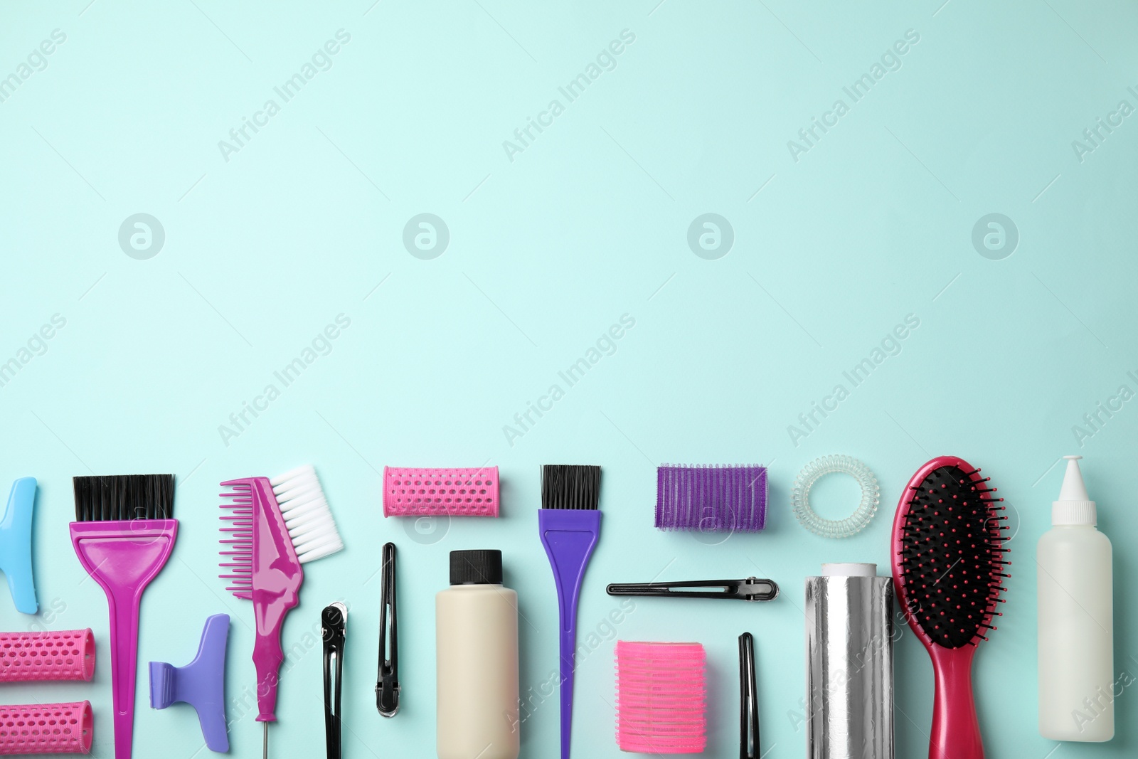 Photo of Professional tools for hair dyeing on light blue background, flat lay. Space for text