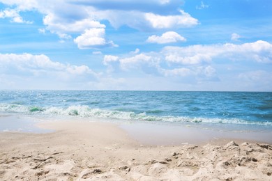 Tropical sandy beach washed by sea on sunny day