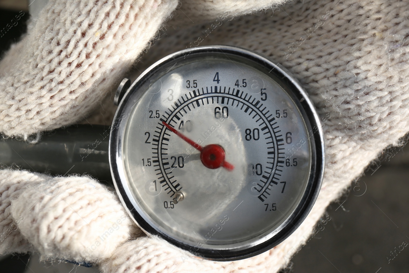 Photo of Mechanic checking tire air pressure at car service, closeup