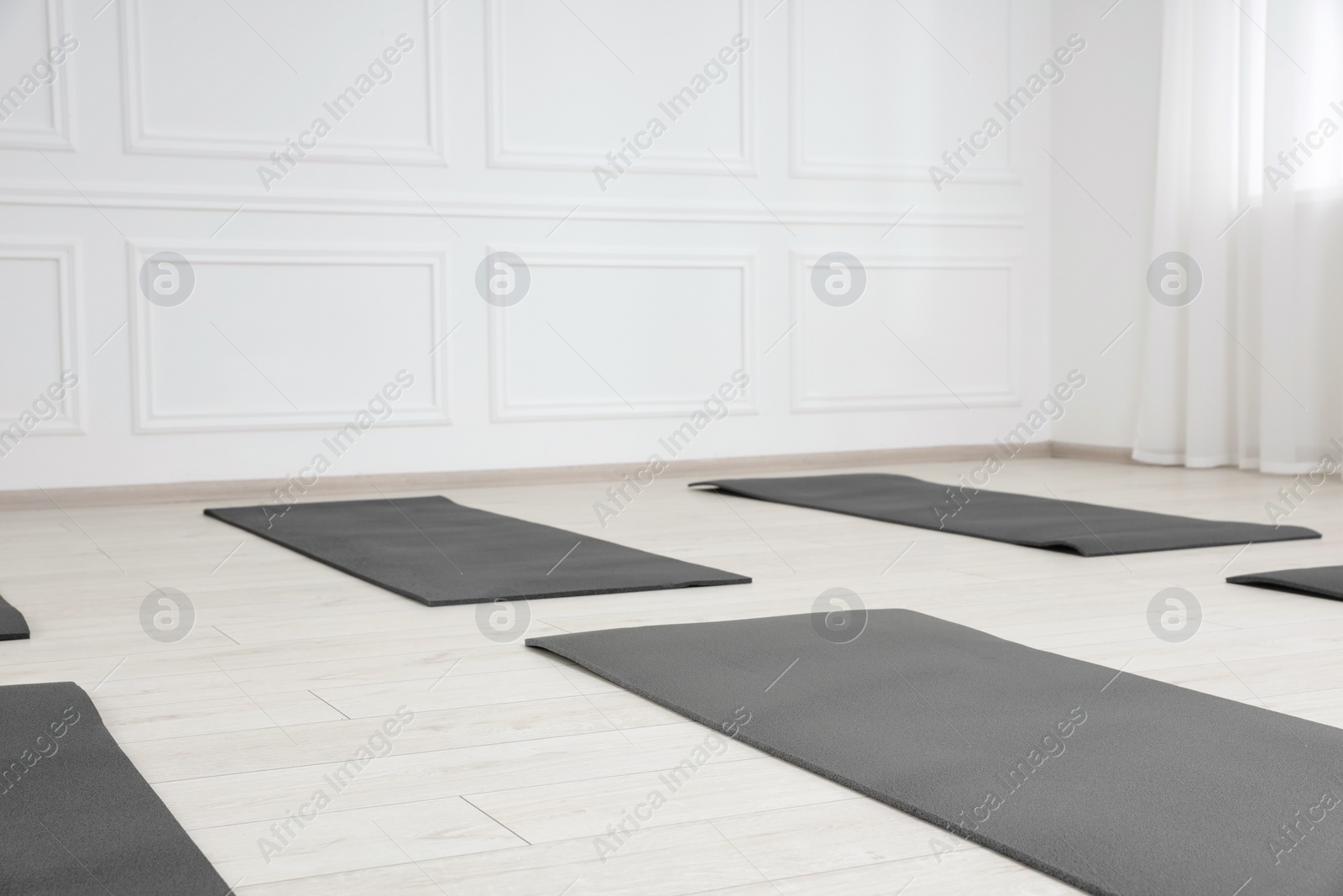 Photo of Spacious yoga studio with exercise mats. Space for text