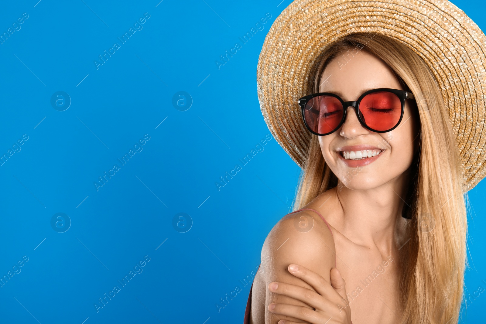 Photo of Beautiful woman in stylish sunglasses on light blue background, space for text