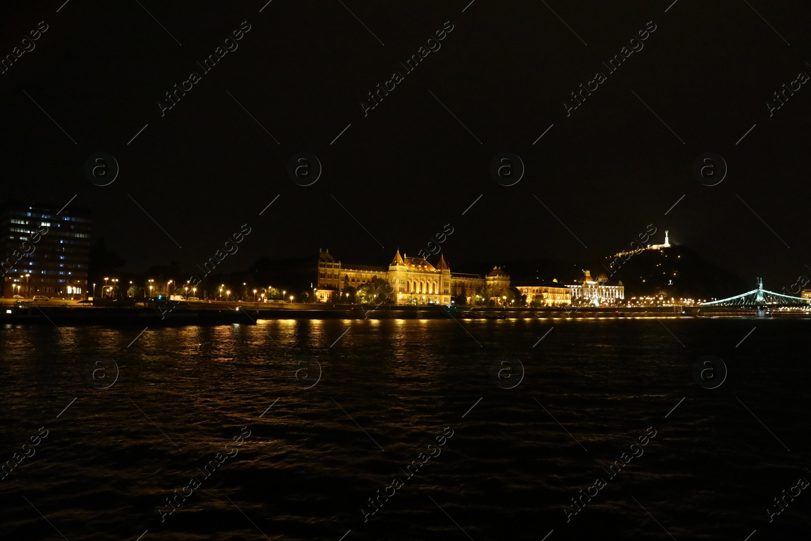 Photo of BUDAPEST, HUNGARY - APRIL 27, 2019: Beautiful night cityscape with illuminated Gellert Hotel and University of Technology and Economics