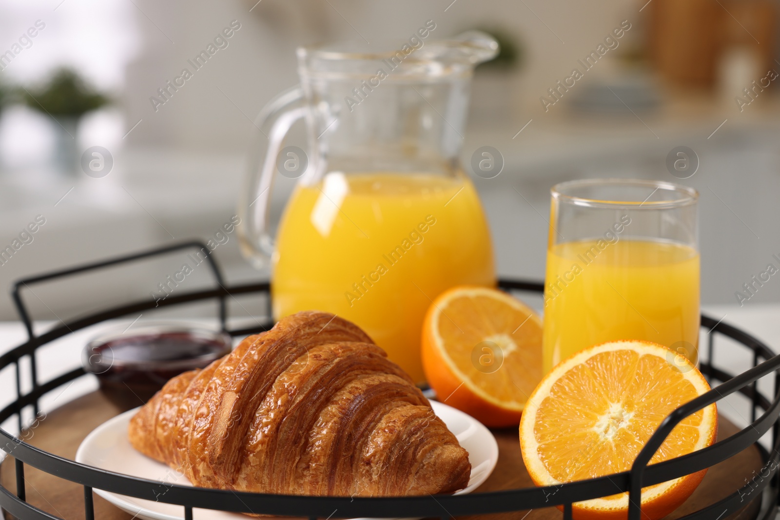 Photo of Breakfast time. Fresh croissant, jam and orange juice in tray