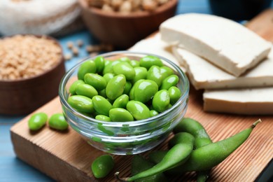 Photo of Fresh green soy beans and other organic products on light blue table, closeup