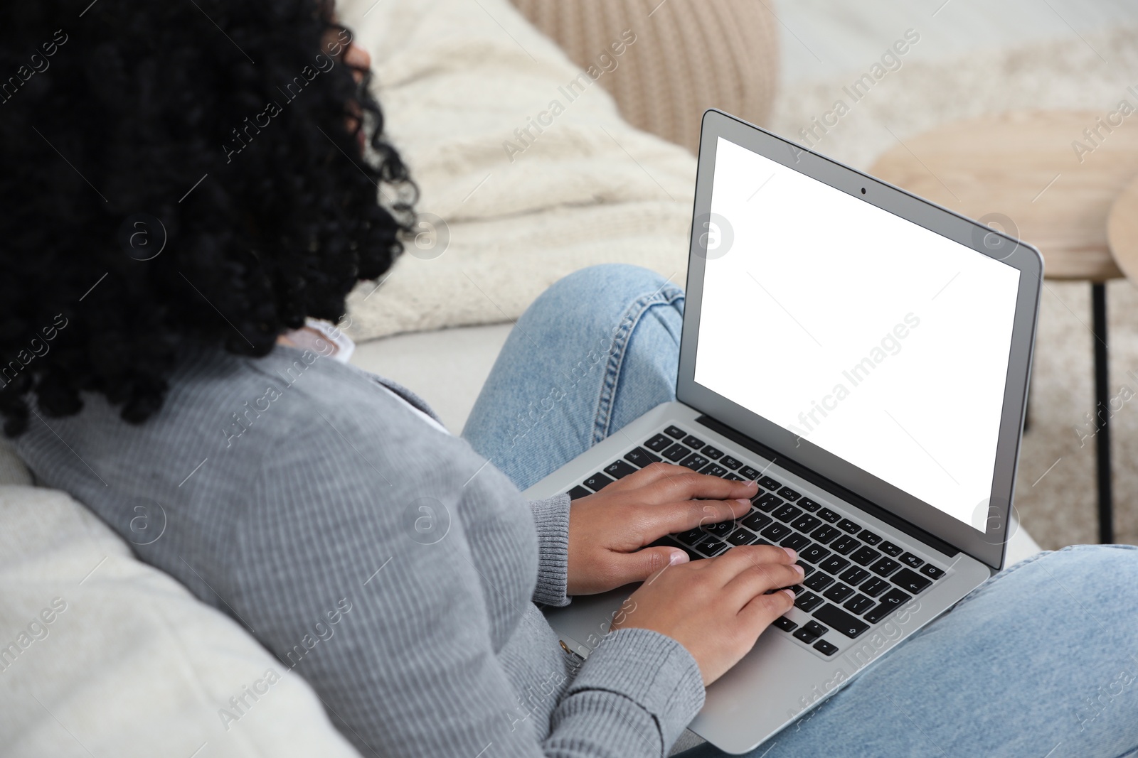 Photo of Woman using laptop on sofa indoors, closeup