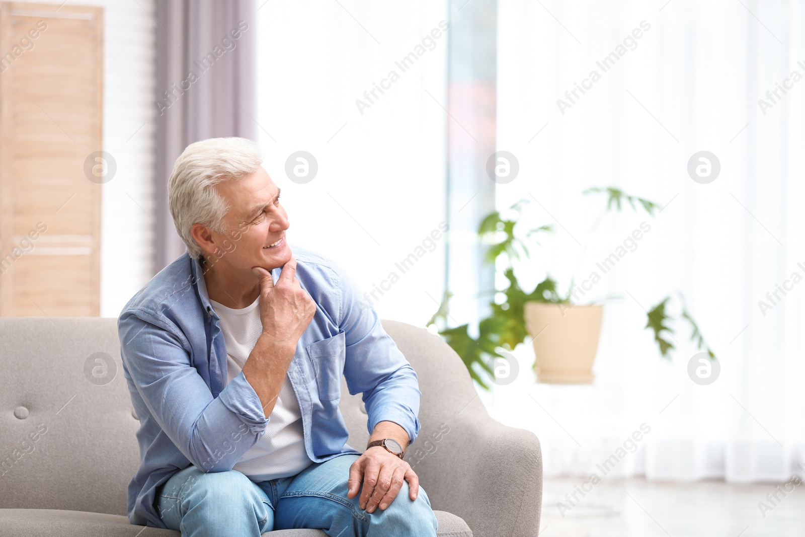 Photo of Portrait of handsome mature man on sofa indoors