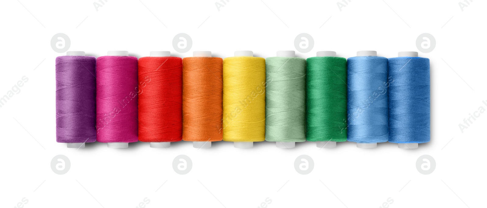 Photo of Set of different colorful sewing threads on white background, top view