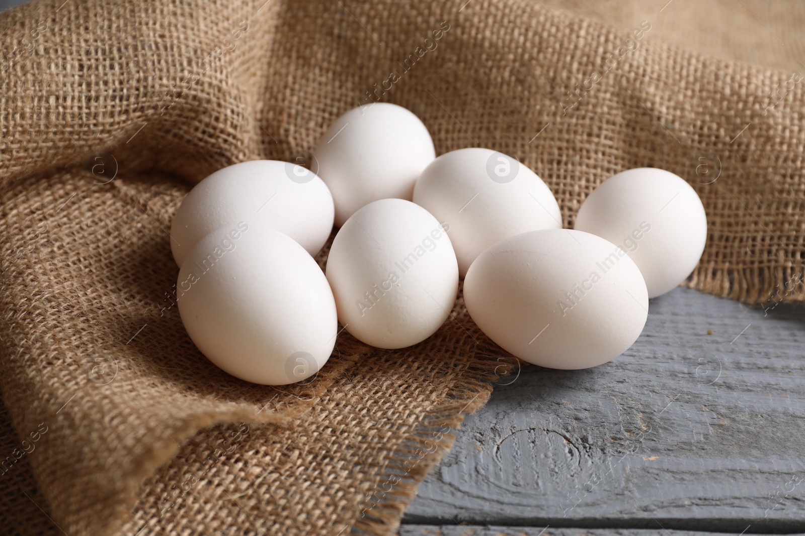 Photo of Fresh chicken eggs on grey wooden table, closeup