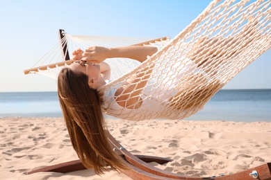 Young woman relaxing in hammock on beach