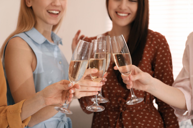 Photo of Young ladies clinking glasses of champagne, closeup. Women's Day