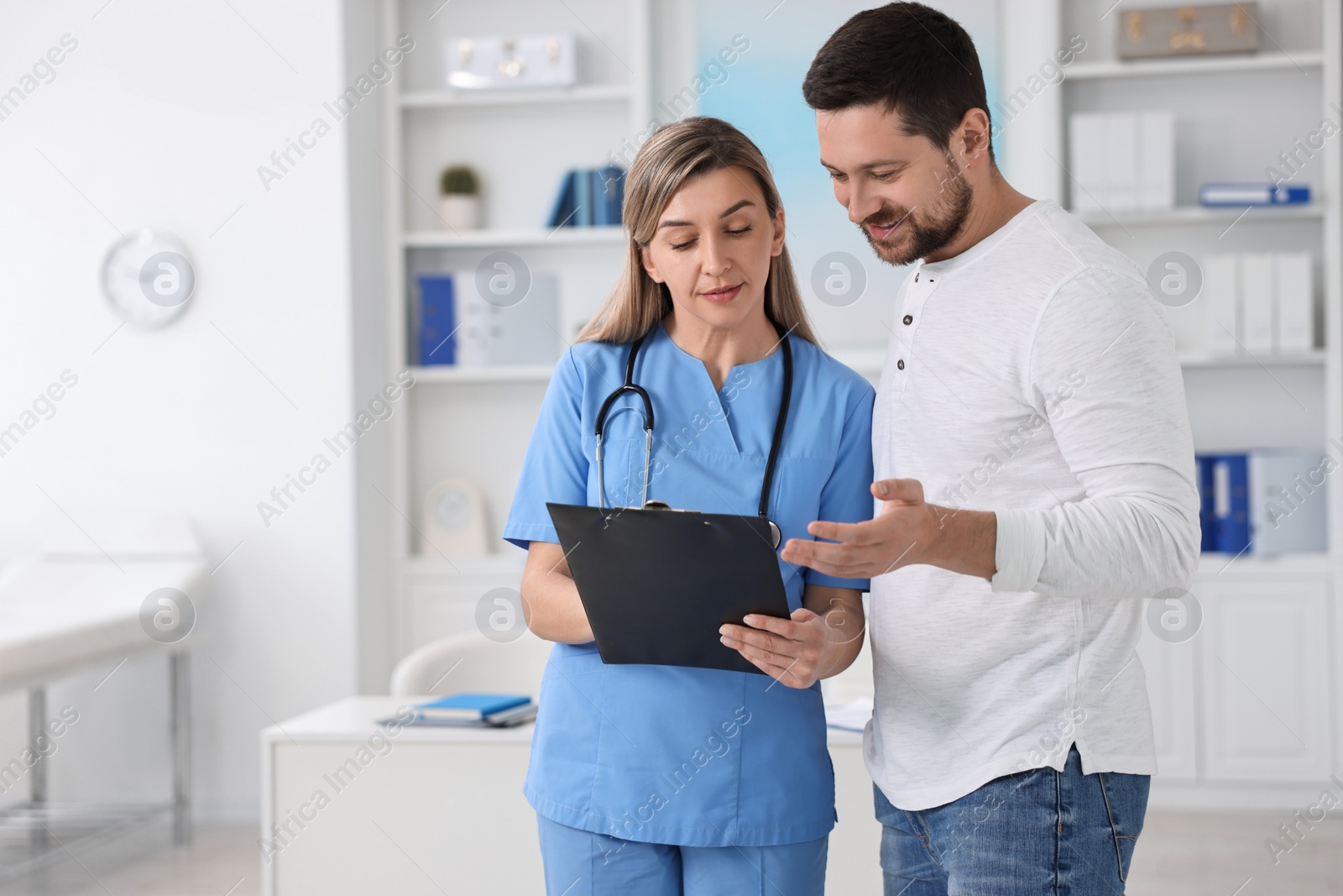 Photo of Professional doctor working with patient in hospital, space for text