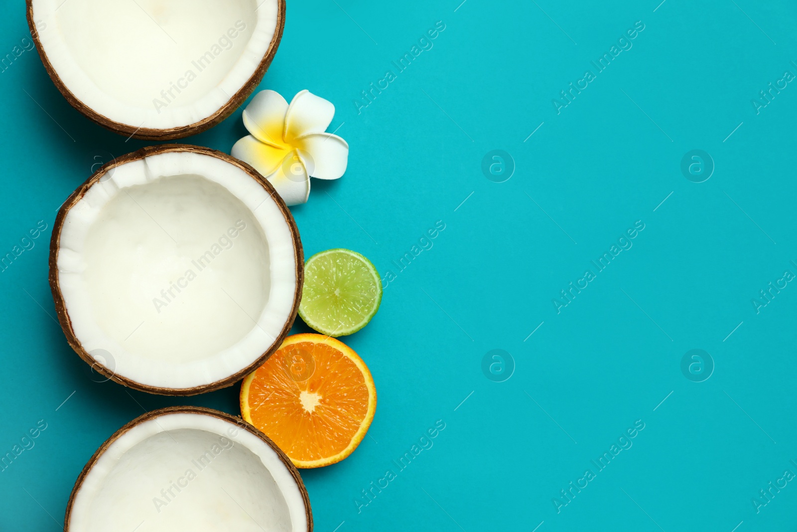 Photo of Flat lay composition with fresh coconut halves on blue background. Space for text