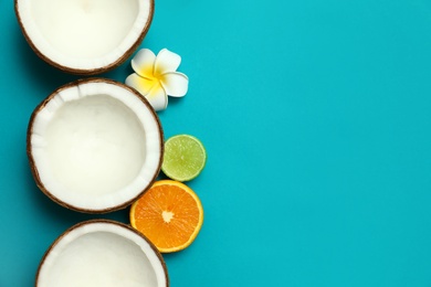 Flat lay composition with fresh coconut halves on blue background. Space for text