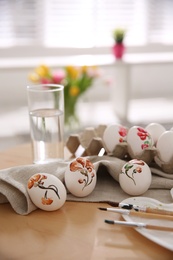Photo of Beautifully painted Easter eggs on wooden table indoors