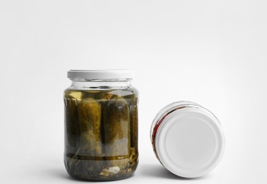 Photo of Glass jars with pickled cucumbers and bell peppers on white background