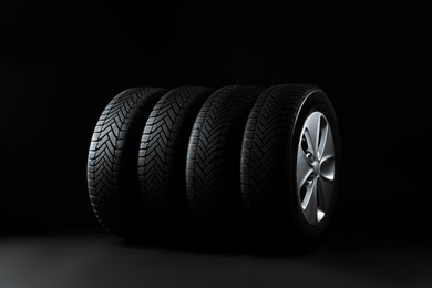 Photo of Set of wheels with winter tires on black background