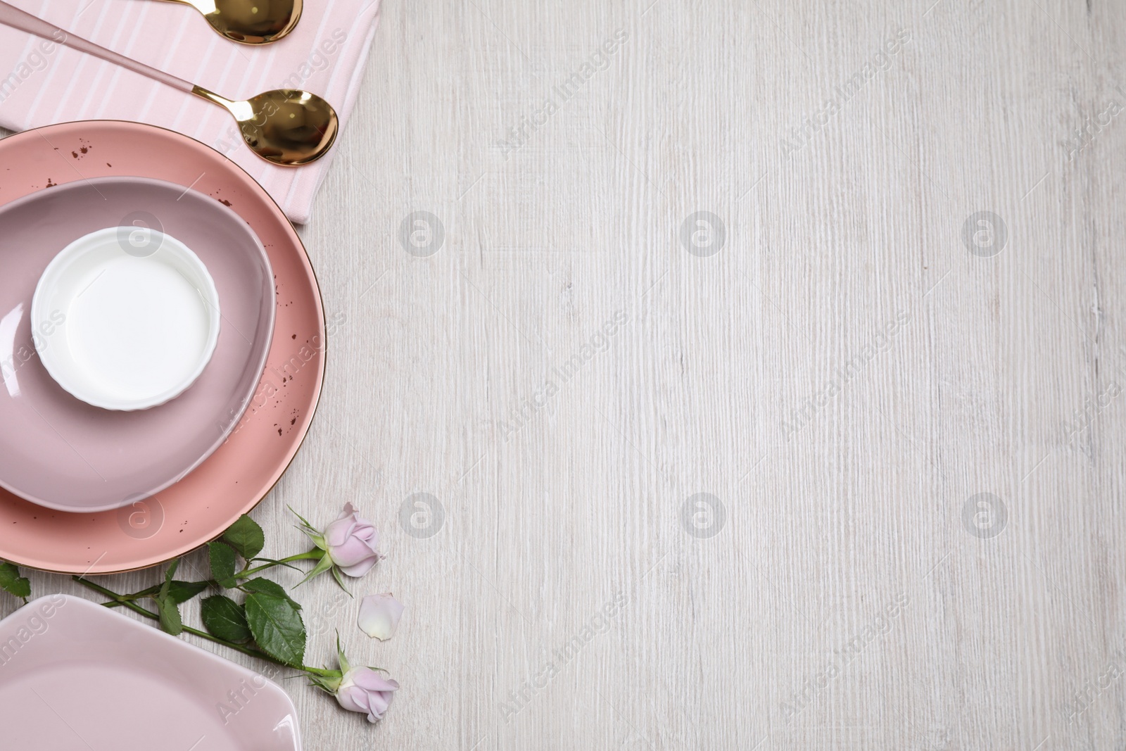 Photo of Flat lay composition with beautiful dishware and roses on white wooden table. Space for text