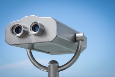 Photo of Metal tower viewer against blue sky, closeup. Mounted binoculars