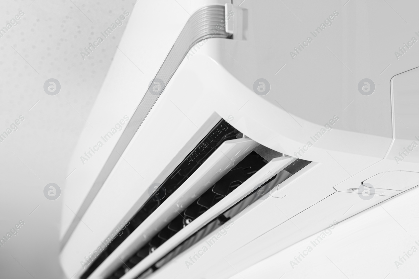 Photo of Modern air conditioner on white wall, closeup