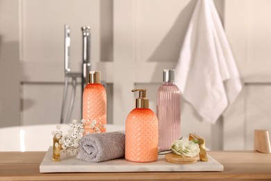 Liquid soap and other toiletries on wooden table in bathroom