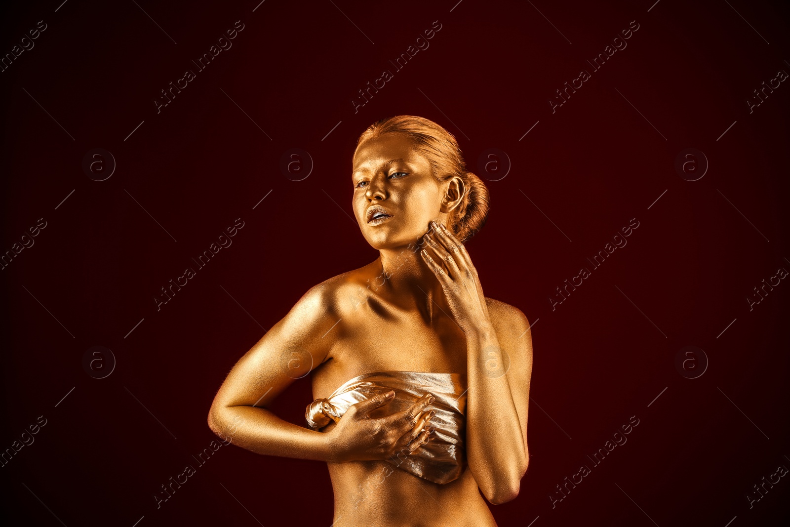 Photo of Portrait of beautiful lady with gold paint on skin against color background