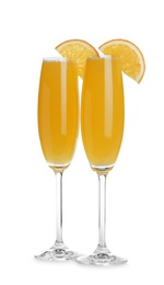 Fresh alcoholic Mimosa cocktails with orange slices on white background