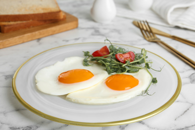 Tasty fried eggs with tomato and sprouts on white marble table, closeup