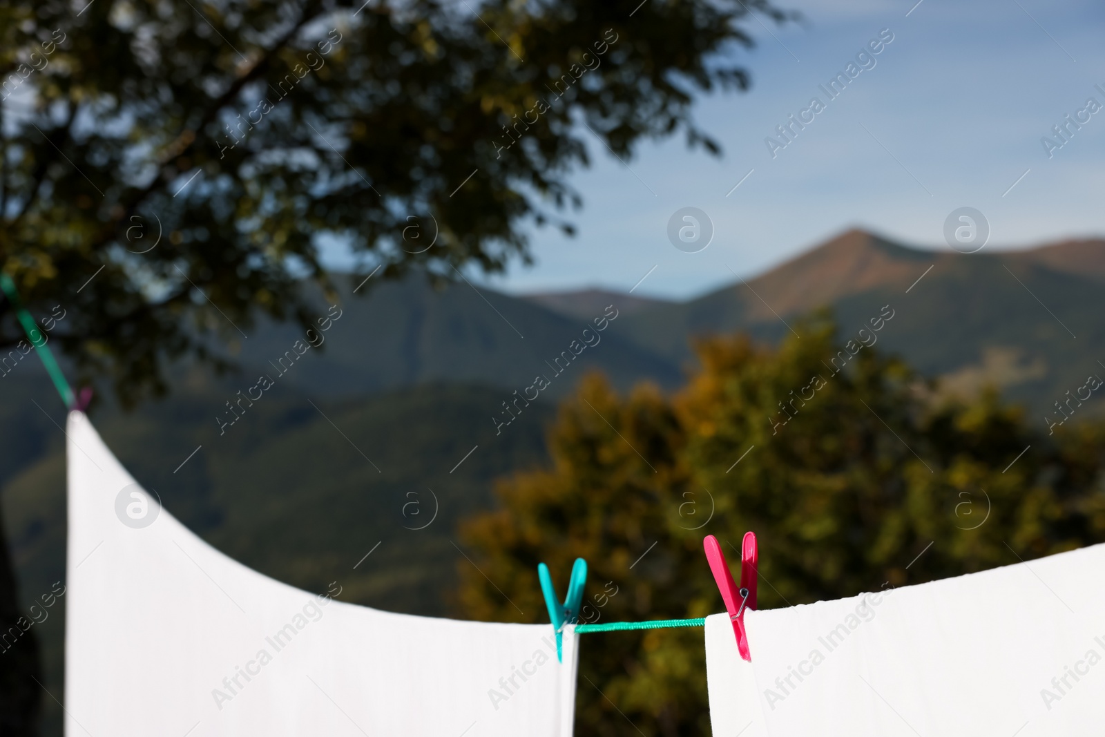 Photo of Laundry with clothes pins on line outdoors. Space for text