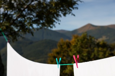 Laundry with clothes pins on line outdoors. Space for text